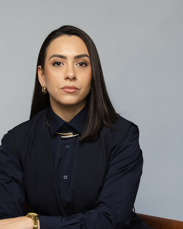 Dra. Jayne Aranda Campos, advogada, sentada em poltrona